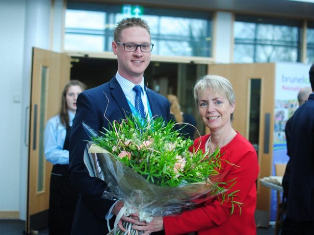  MP, Karin Smyth holding a bouquet of flowers with Lee Probert, Principal and Chief Executive